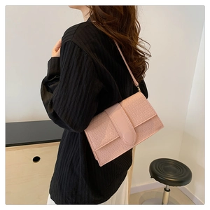 Detail of pink rectangular crossbody bag with geometric triangle embossed pattern texture