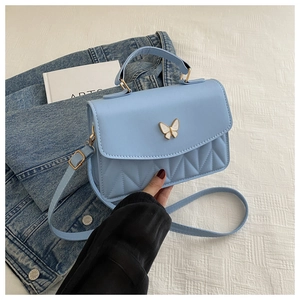 Detailaufnahme hellblaue Umhängetasche mit Schmetterlingsdekor und geometrischer Naht
