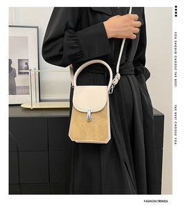 Close-up of contrast color crossbody bag with silver lock and khaki suede texture