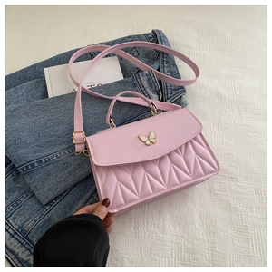 Detail der rosa gesteppten Handtasche mit weißer Schmetterlingsschließe und Gurt