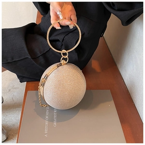 Detail of champagne gold sphere evening bag with glitter coating and rhinestone handle