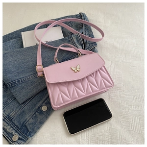 Detailansicht einer rosa gesteppten Umhängetasche mit Schmetterlingsverschluss auf Denim