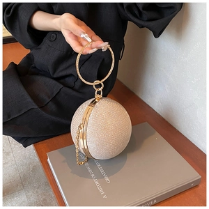Detail of champagne gold sphere evening bag with sequins and round metal handle
