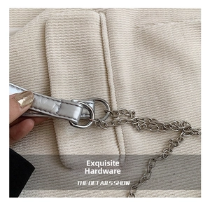 Detail van de zilveren metalen ketting en ring op de corduroy schoudertas