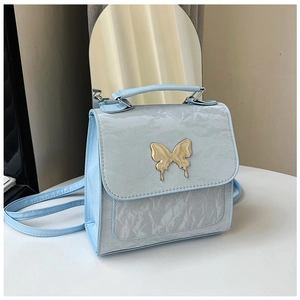 Detail of light blue wrinkled faux leather handbag with gold butterfly metal clasp