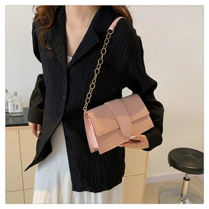 Pink crossbody bag with geometric triangle texture and gold chain strap detail