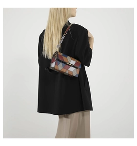 Detail of geometric patchwork crossbody bag with metal bar and acrylic chain strap
