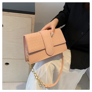 Detail of pink geometric embossed handbag with gold chain and adjustable strap