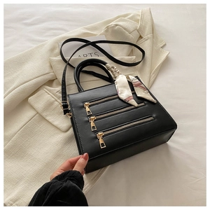 Detail view of black PU leather square bag with triple zippers and silk scarf handle