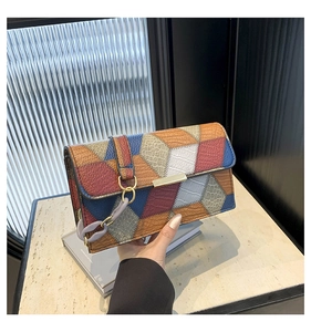 Detail of color-block flap bag featuring crocodile and lychee leather textures