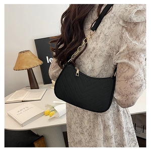 Detail of black V-quilted faux leather shoulder bag with gold chain and zipper detail