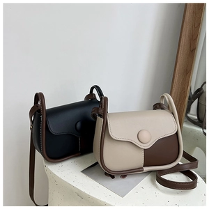 Detail view of retro leather crossbody bags with contrast stitching and decorative round buckles