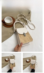 Detail of off-white and khaki leather handbag with silver metallic buckle and shoulder strap