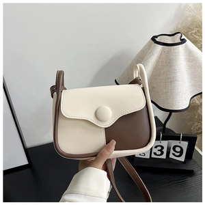 Detail of vintage square crossbody bag with contrast beige and brown faux leather trim