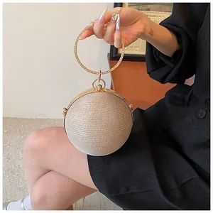 Detail of champagne gold spherical evening bag with diamond-encrusted round handle