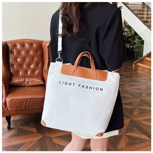 Detail of vintage canvas tote bag with leather handles and Light Fashion lettering