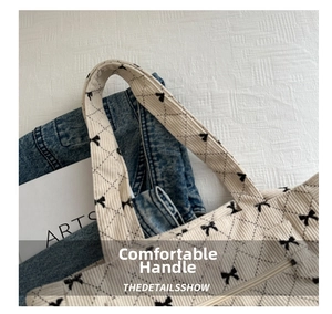 Detail of corduroy tote bag showing stitching on handle and bow pattern print