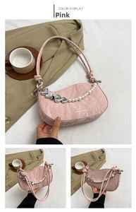 Detail view of pink shoulder bag with pearl heart chain and leather texture
