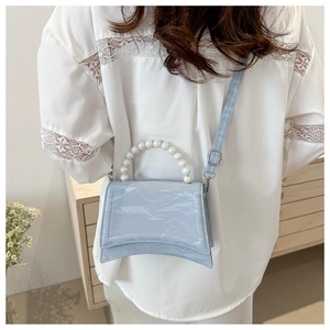 Light blue patent leather handbag with pearl handle and curved hourglass base design
