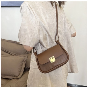 Detailed view of brown PU leather crossbody bag with quilted texture and gold clasp