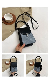 Detail of elegant black and blue square handbag with metal clasp and leather handle