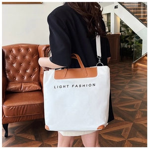 Detail of canvas tote bag with leather trim and Light Fashion text on interior background