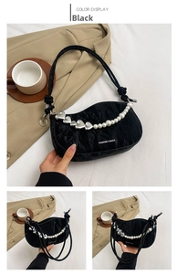 Detail of black pleated shoulder bag with white pearls and silver heart-shaped chain