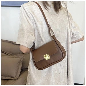 Detailed view of brown crossbody bag with diamond lattice pattern and gold square lock