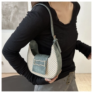 Detailed close-up of a crescent hobo bag featuring contrast textures and gold buckle
