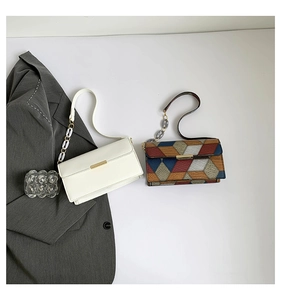 Flat lay of cream white and geometric patchwork shoulder bags with gold buckles