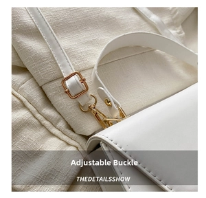 Detail shot of the golden metal adjustable buckle on a premium white leather handbag