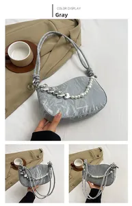 Détail du sac à bandoulière plissé gris avec chaîne en perles et breloque cœur