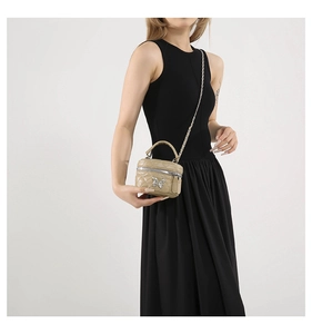 Close-up of beige quilted mini bucket bag with silver butterfly and chain strap