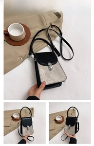 Detail view of stylish two-tone crossbody bag featuring grey suede and black leather accents