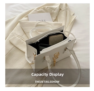 Internal view of white leather handbag showing spacious compartments with phone and wallet