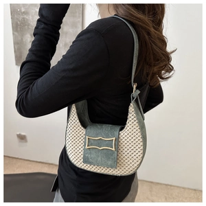 Détail des coutures contrastées et du sac hobo croissant avec boucle métallique dorée