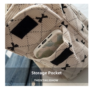 Detail of corduroy tote bag featuring a front pocket for smartphone storage with velcro