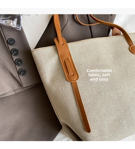 Detail of waterproof nylon tote with high-quality beige canvas texture and brown leather strap