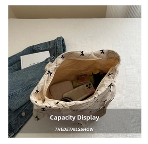 Interior view showing the large capacity of a white corduroy bow tote bag with essentials