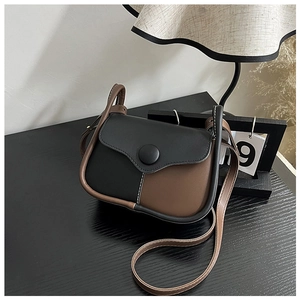 Close-up of retro color-block crossbody bag with white contrast stitching and magnetic snap