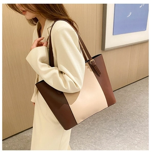 Detail of dark brown and beige contrast stitching tote bag with adjustable strap
