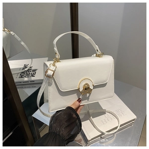 Detailed close-up of white PU leather handbag with elegant gold circular swivel lock