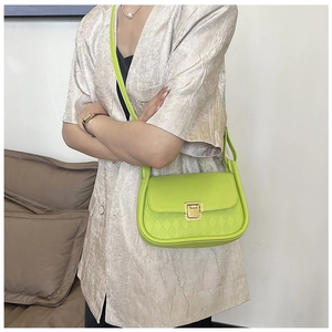 Detail of neon green shoulder bag featuring diamond lattice pattern and gold square lock