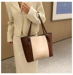 Detail of tricolor PU leather tote bag showing gold metal buckle and shoulder strap fit