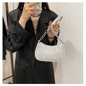 Close-up of light grey felt shoulder bag with quilted pattern and gold chain strap