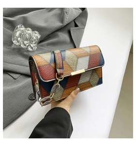 Detailed view of retro geometric patchwork shoulder bag with pebble grain leather and metal link