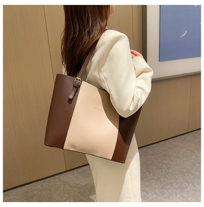 Model carrying a tri-color PU leather tote bag with coffee and beige panel design