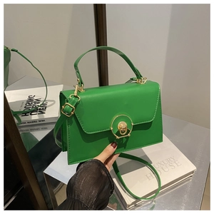 Detailed shot of bright green faux leather handbag with elegant gold circular lock closure