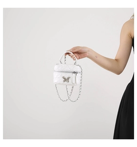 White quilted mini box bag with silver metal handle and butterfly charm detail