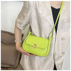 Detail of neon green crossbody bag with diamond texture and gold metal buckle